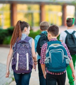 elementary students walking to school with backpacks