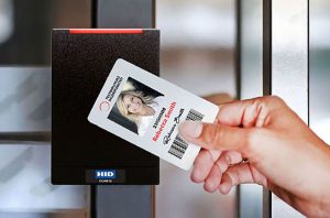 worker swiping keycard on commercial access control card reader