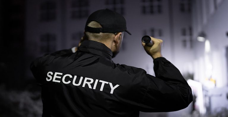 Security Guard Patrolling Business Property Shinning Flashlight