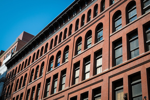 Old Red Brick Warehouse Building in City Renovated into Multifamily Apartment Housing