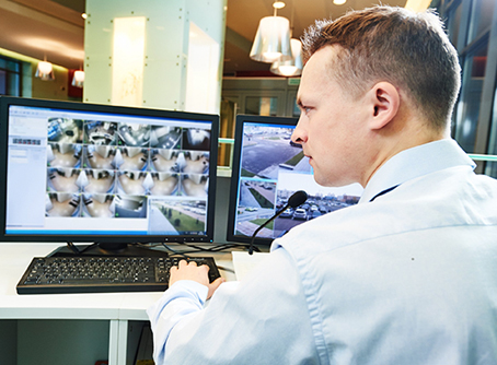 Security Guard Viewing Surveillance Video on Screen at Alarm Monitoring Center in St Louis