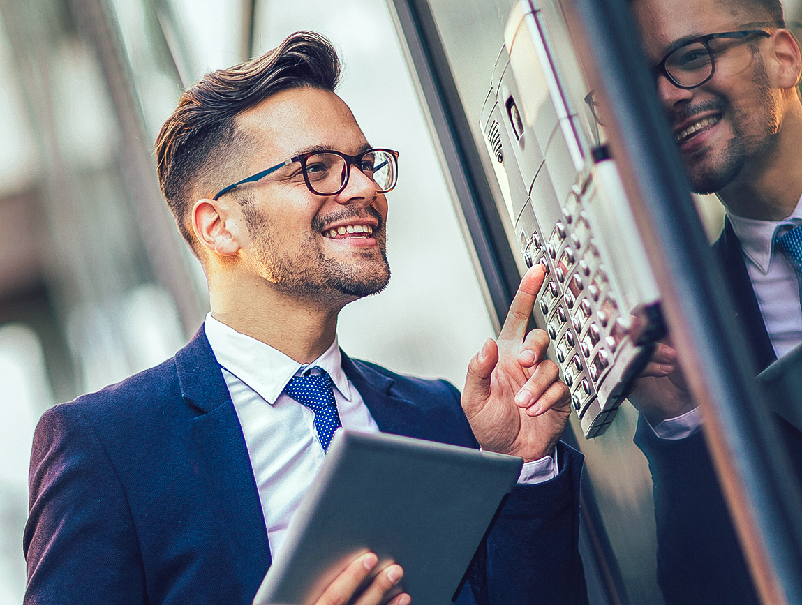 Young Businessman Talking Into Business Access Control Intercom System