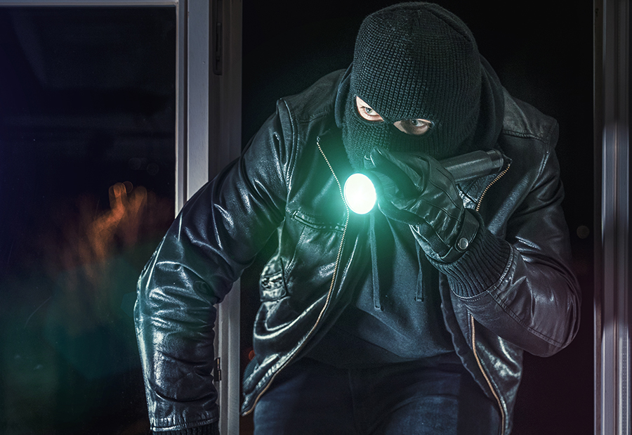Masked Burglar with Flashlight Breaking into Commercial Building