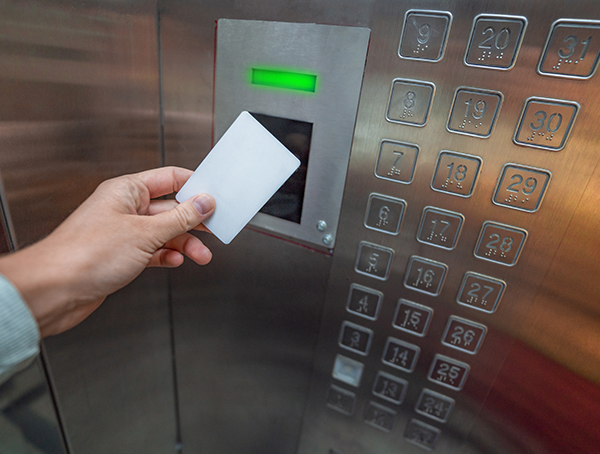 person using carder reader access control in elevator