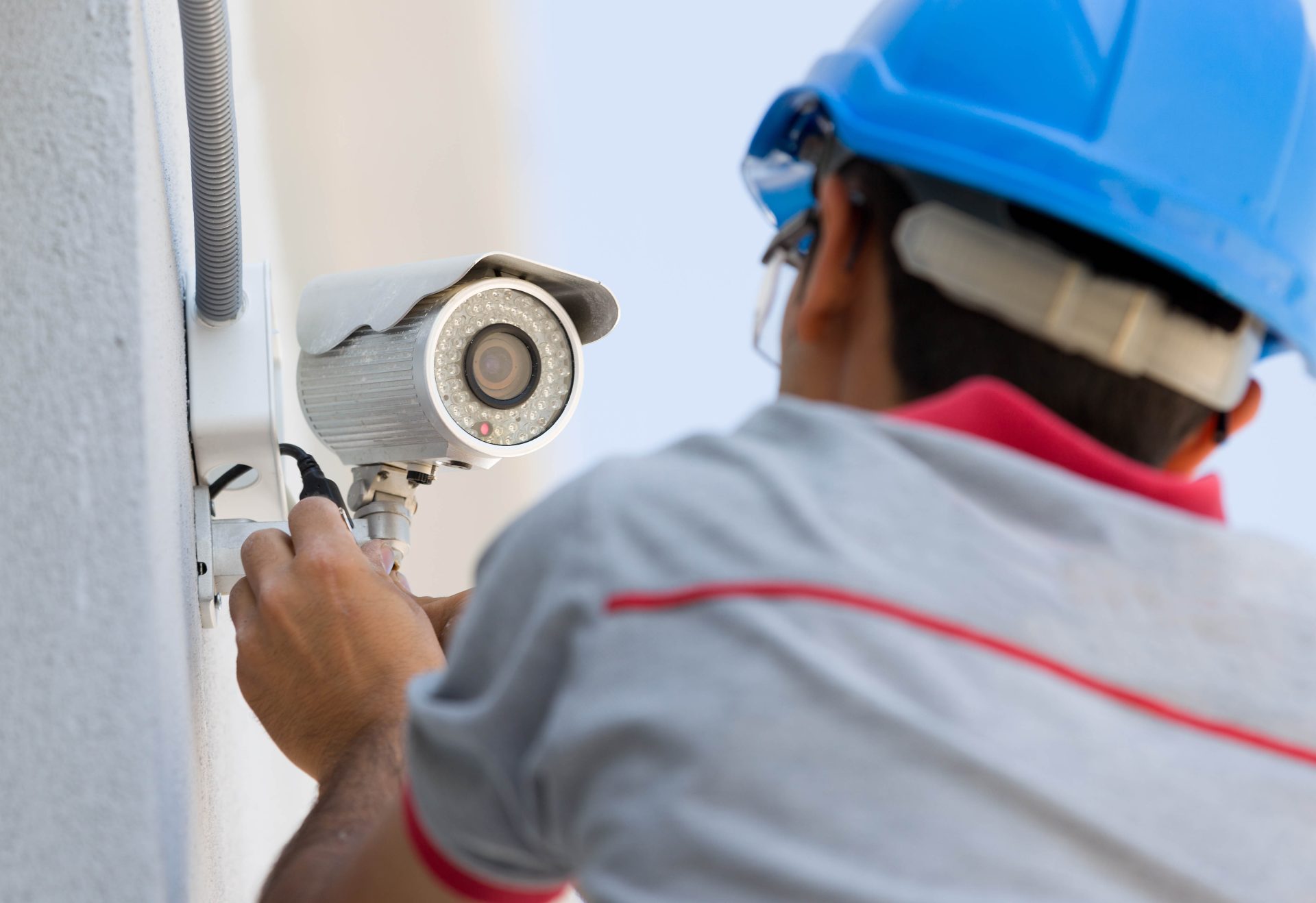 Technician Installing Security Camera on Office Building