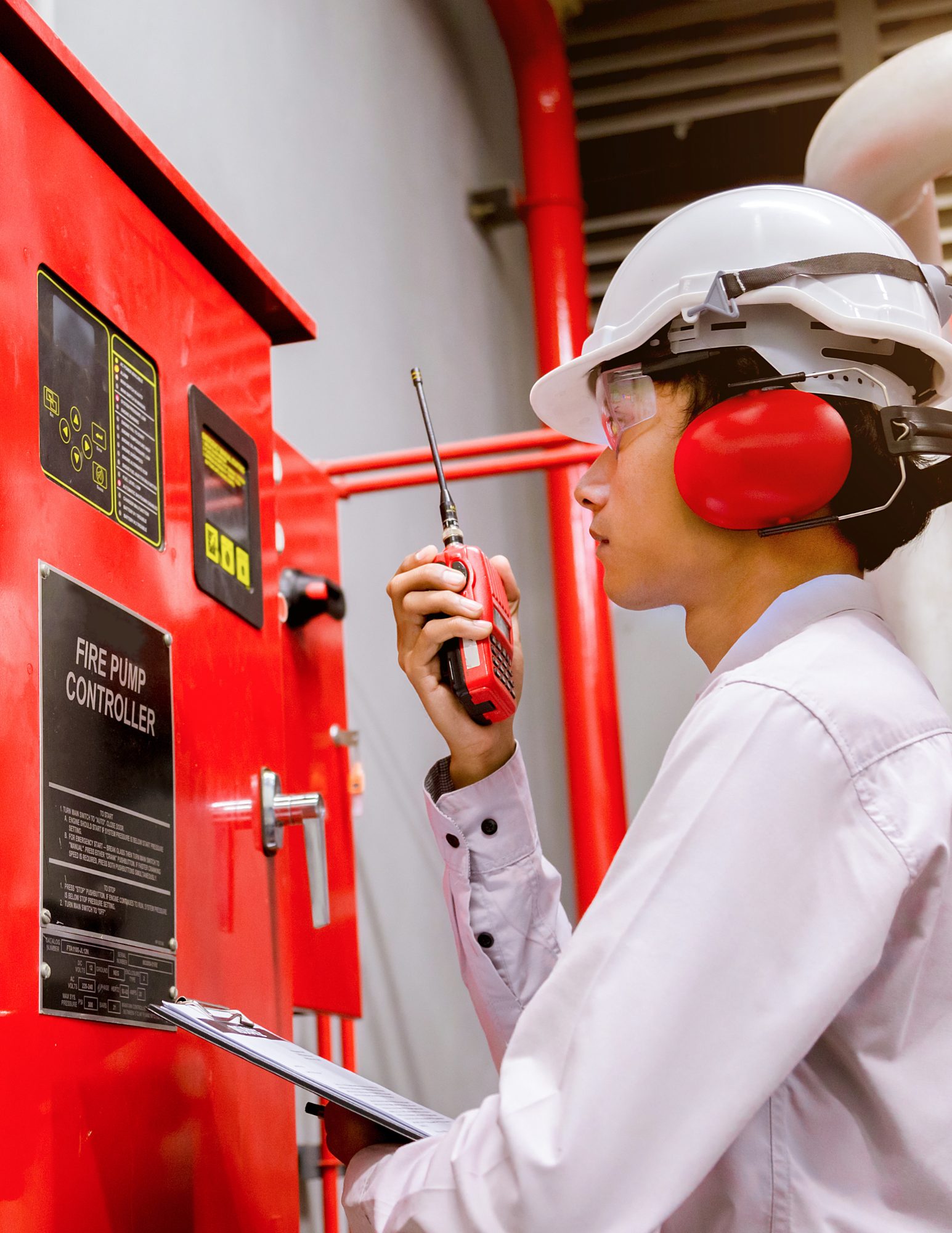 Vertical image of Woman inspecting fire system