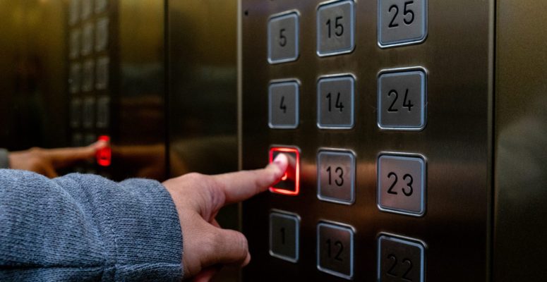 Person pressing elevator button to the lobby